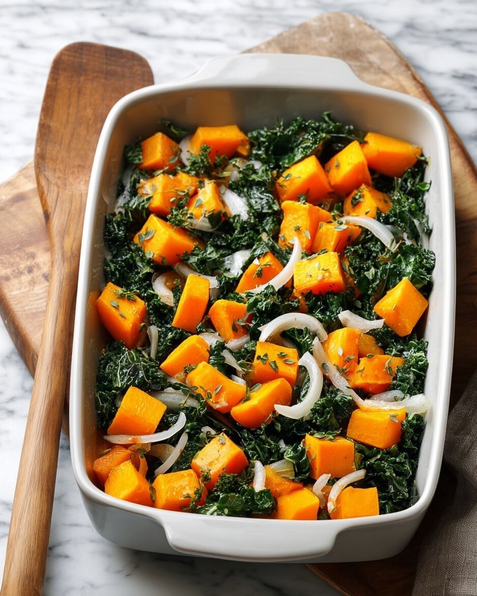 A white rectangular baking dish filled with rough chopped dark green kale as the base layer, topped with bright orange cubed pieces of butternut squash scattered evenly across the dish, and thinly sliced white onions spread on top, all mixed together with small bits of fresh green herbs throughout. The dish sits on a white marbled surface with a wooden handle utensil on the left side. photo taken with an iphone --ar 4:5 --v 7