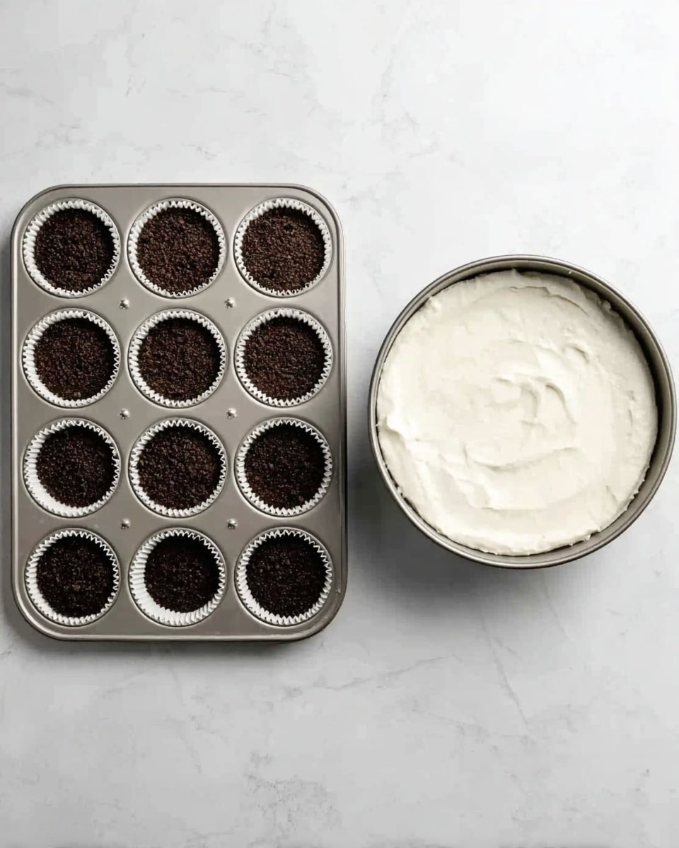 The image shows two side-by-side photos on a white marbled surface. On the left, a metal muffin tray holds 12 white cupcake liners, each filled with a layer of dark brown crumbly crumbs. On the right, a round metal springform pan is filled with a smooth, thick white creamy layer that spreads evenly across the surface. Photo taken with an iphone --ar 4:5 --v 7
