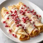Eggnog Crepes with Eggnog Sauce, Pomegranate Arils, and Powdered Sugar Recipe