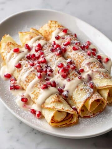 Eggnog Crepes with Eggnog Sauce, Pomegranate Arils, and Powdered Sugar Recipe