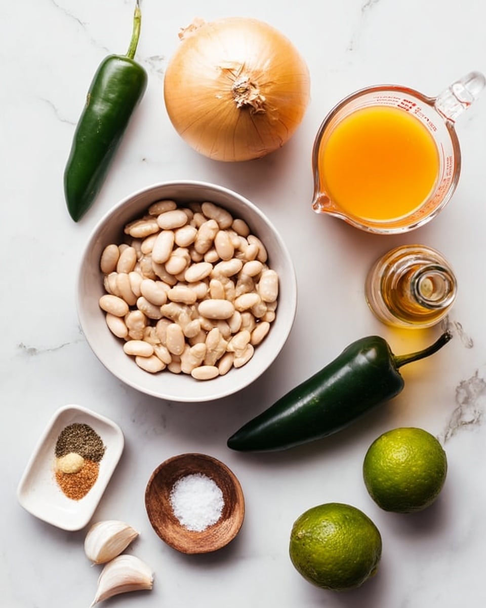 This image shows a top view of several cooking ingredients placed on a white marbled surface. At the center is a white bowl filled with pale, soft white beans. Above the bowl, there is a whole yellow onion. To the right of the onion, a clear glass measuring cup holds an orange-yellow liquid. Below that, a small bottle contains a golden liquid, likely oil. To the right of the bowl is a dark green poblano pepper. Below the bowl, a whole lime, two white garlic cloves, and a small white dish with ground spices in brown and beige colors sit spread out. To the left of the bowl, there is a bright green jalapeño pepper and a small wooden dish with white salt. The whole scene is balanced, with fresh and natural ingredients clearly arranged. photo taken with an iphone --ar 4:5 --v 7