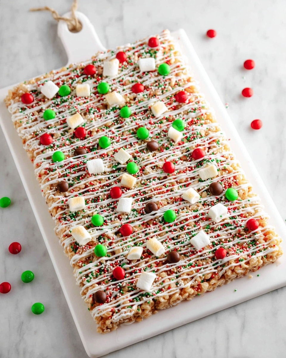 A large rectangular rice crispy treat lays flat on a white cutting board with a handle, covered in small red, green, and white round sprinkles scattered evenly. The treat is drizzled diagonally with white icing that creates thin, wavy lines across the surface. On top, there are small toasted marshmallows and red and green candy-coated chocolates spread all over. The white marbled surface is visible around the cutting board. photo taken with an iphone --ar 4:5 --v 7