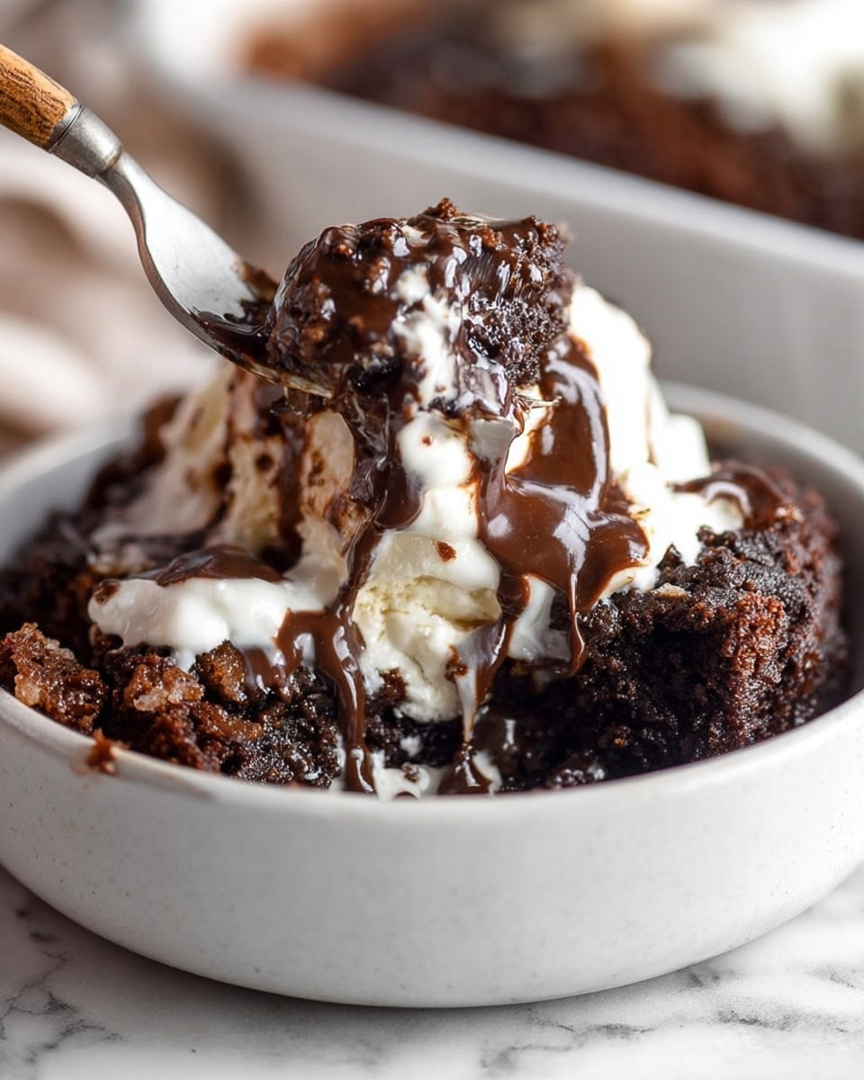 The image shows a close-up of a rich dessert served in a white bowl on a white marbled surface. The dessert has three main layers: a dark brown, moist, crumbly chocolate cake base; a middle layer of thick, melted dark chocolate sauce spreading unevenly; and a top layer of soft, white cream or vanilla ice cream melting slightly into the chocolate. A fork with a wooden handle is picking up a chunk of the dessert, blending all layers together, with some chocolate sauce dripping slightly over the edges. The background is softly blurred, keeping the main focus on the textured, gooey dessert. Photo taken with an iphone --ar 4:5 --v 7