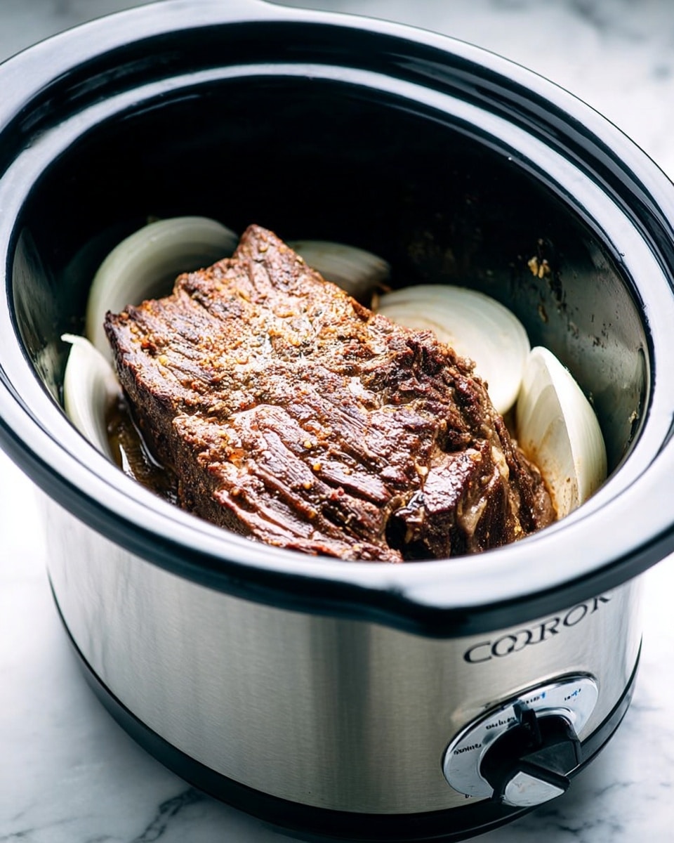 A close-up image of a slow cooker with a silver outer body and black inner pot, filled with a large piece of cooked meat placed on top of thick slices of white onions. The meat has a dark brown, textured surface with visible seasoning and a slight shine from cooking juices. The slow cooker is set on a white marbled surface, and the front dial is turned to low or high settings. The scene is brightly lit, emphasizing the rich color and texture of the meat. photo taken with an iphone --ar 4:5 --v 7