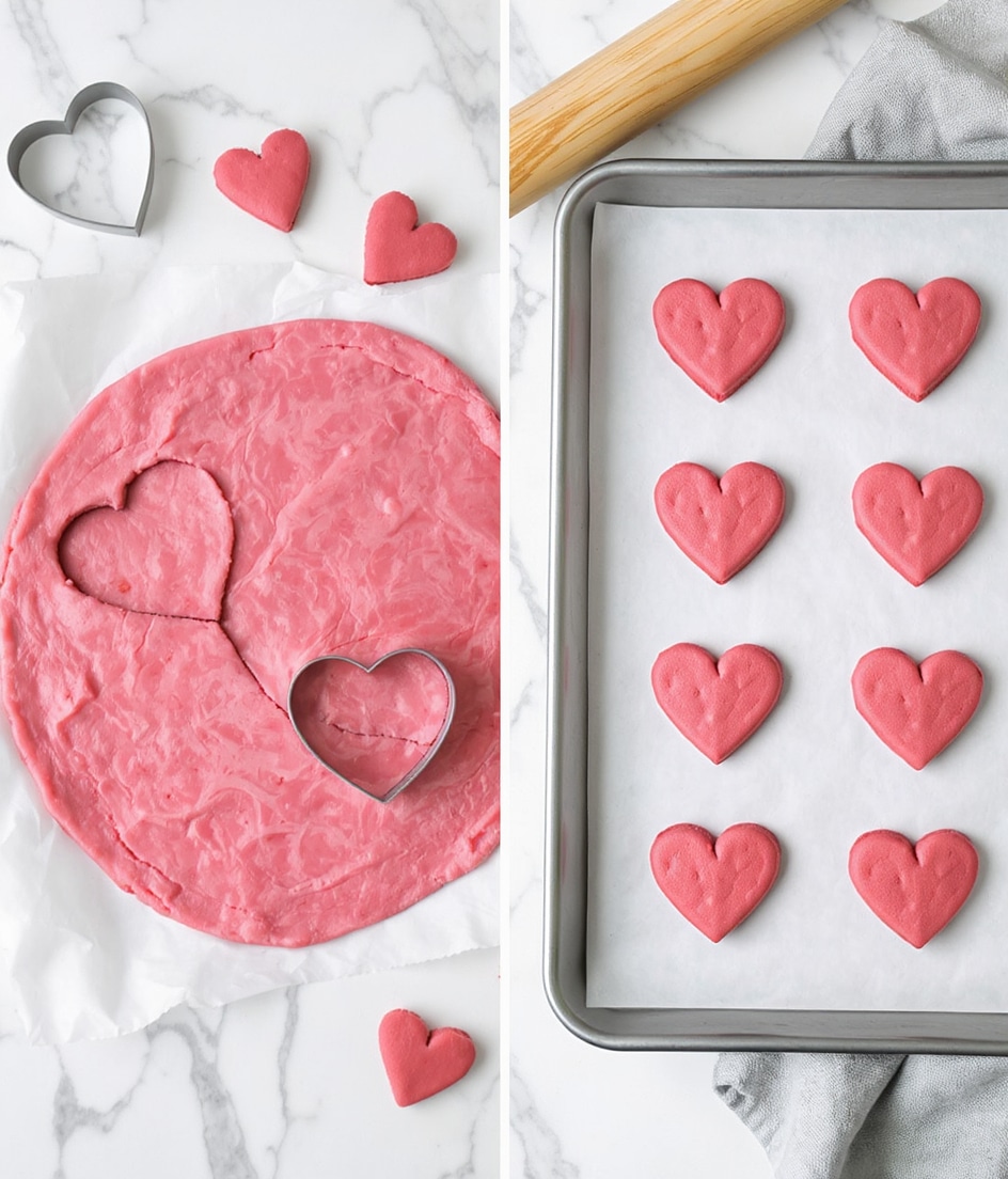 The image shows two side-by-side scenes. On the left, there is a white marbled surface with a round flattened pink dough spread on parchment paper. Four heart shapes are cut out from the dough using a heart-shaped metal cutter, with three heart-shaped dough pieces placed around the dough and the cutter still in use. A wooden rolling pin is seen on the top right corner of this scene. On the right, a silver baking tray lined with white parchment paper holds 12 evenly spaced pink heart-shaped dough pieces ready for baking. Photo taken with an iphone --ar 4:5 --v 7