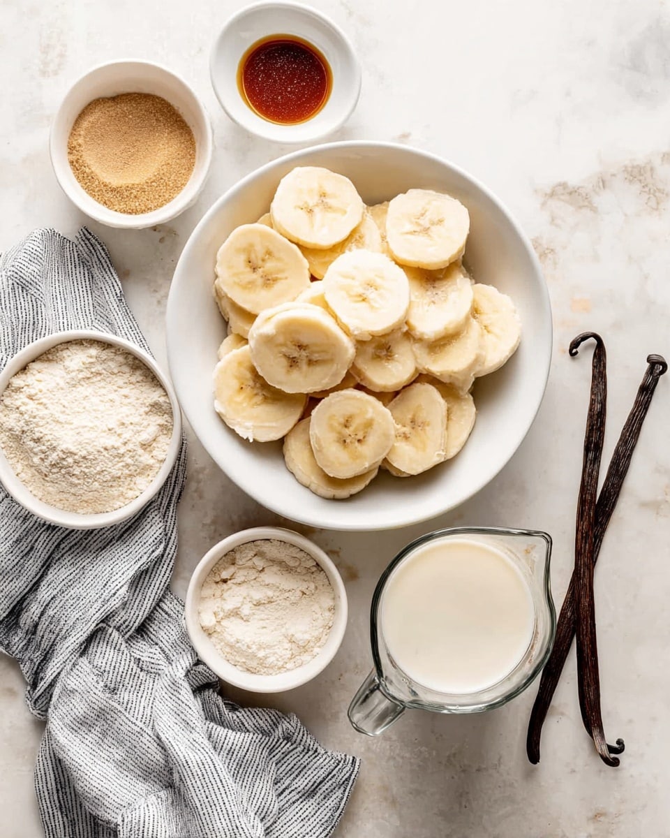A white bowl filled with round slices of light yellow bananas sits in the center. Surrounding it are small white bowls with various ingredients: a bowl with light brown sugar, a smaller bowl of dark brown vanilla extract, and another bowl with beige flour. Below the bowls is a glass measuring cup filled with creamy white milk. To the right side of the bowls, there are two dark brown vanilla pods, and a white marbled surface underneath with a gray and white striped cloth nearby. The scene shows a calm, warm tone with soft natural light, photo taken with an iphone --ar 4:5 --v 7
