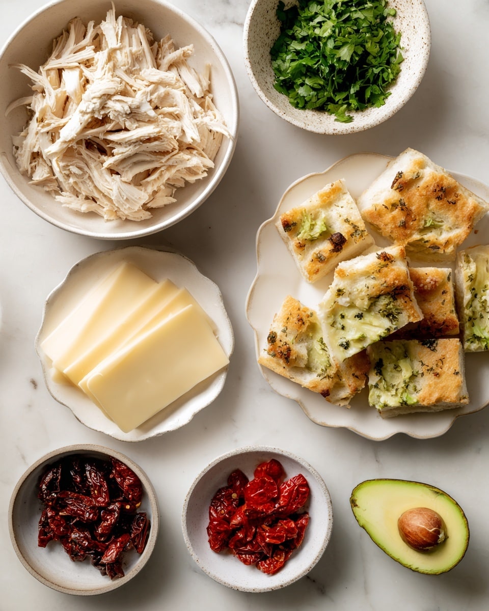 The image shows an overhead view of several white dishes and bowls arranged on a white marbled surface. In the top left is a round bowl filled with shredded rotisserie chicken with pale beige and light brown textures. To the top right is a small speckled white bowl filled with bright green chopped cilantro. Below the chicken bowl, to the left is a white scalloped plate holding several slices of pale yellow gouda cheese, with smooth, firm textures stacked gently. To the right of the cheese plate is a similar scalloped white plate with several pieces of focaccia bread, showing a golden-brown baked top with herbs sprinkled on it, soft yet slightly crisp in appearance. Below the focaccia, there are three small white bowls: the left bowl holds dark red-brown sundried tomatoes with a wrinkled texture, the middle bowl contains shiny red peppadew peppers, and the right bowl, partially visible, holds a dollop of creamy white mayo. Lastly, at the bottom right of the image, a halved avocado with a seed in the middle and smooth green flesh is placed directly on the white marbled surface. photo taken with an iphone --ar 4:5 --v 7
