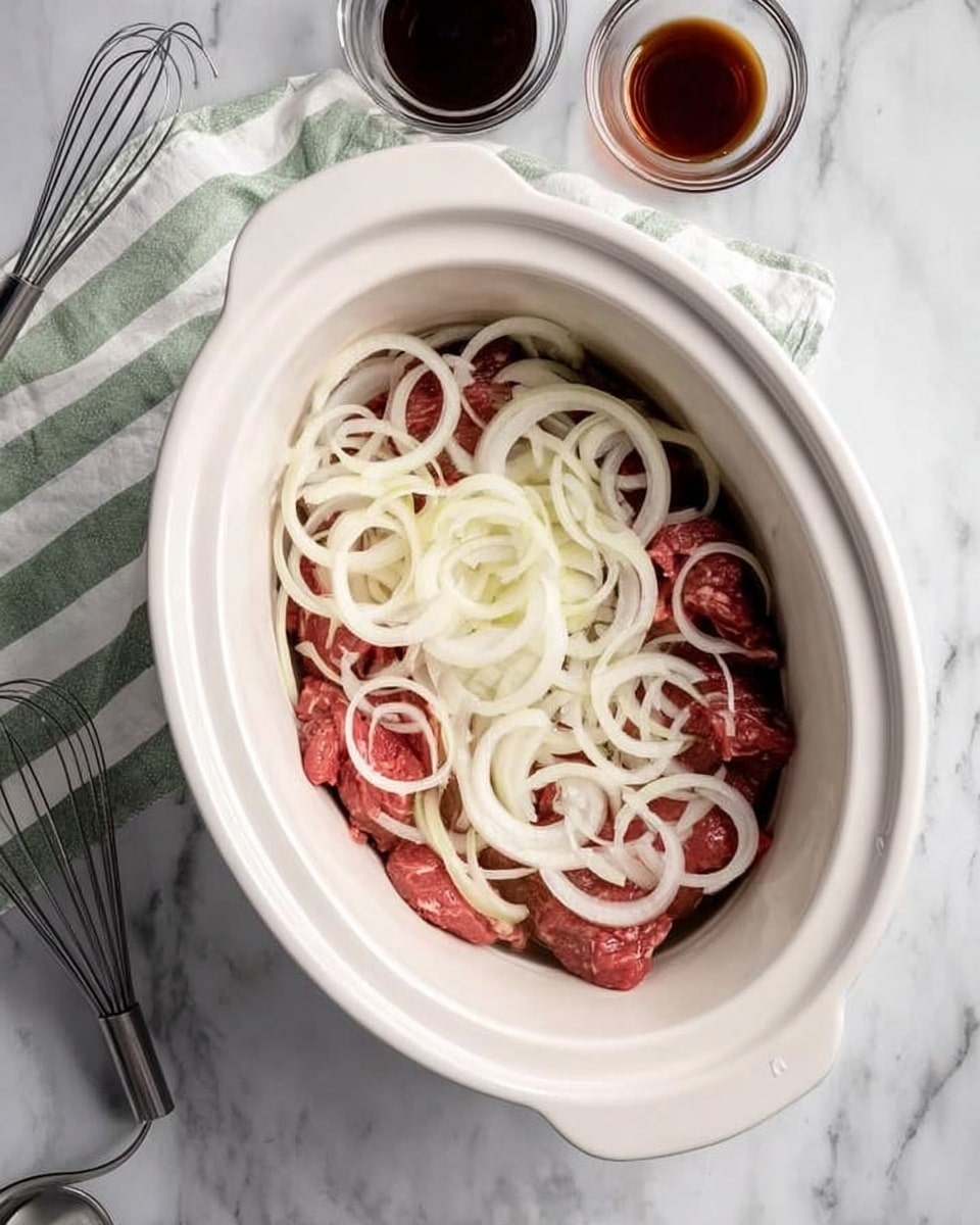 The image shows a white oval slow cooker filled with layers of food. At the bottom are several raw meat pieces with a pinkish-red color. On top of the meat, there is a generous layer of sliced white onions arranged loosely with curved rings and some overlapping. The slow cooker sits on a white marbled surface, next to a silver whisk and a green and white striped cloth. There are two small glass bowls near the slow cooker, one with dark brown liquid and the other partially visible with a darker liquid inside. Photo taken with an iphone --ar 4:5 --v 7