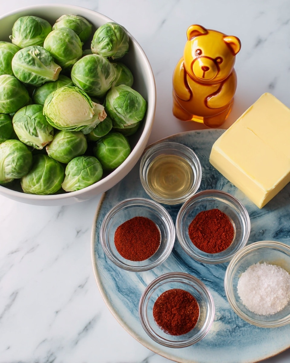 The image shows a white bowl on the left filled with fresh green Brussels sprouts with tight leaves and some stems visible, layered naturally. To the right, there is a round white plate with a blue marbled texture holding a small yellow bottle shaped like a bear filled with golden honey, a rectangular block of pale yellow butter, and five small clear glass bowls arranged loosely. Three bowls contain different red spices with fine powder texture, one bowl has a light golden liquid, and the last bowl is filled with coarse white salt. All items are placed on a white marbled surface. Photo taken with an iphone --ar 4:5 --v 7
