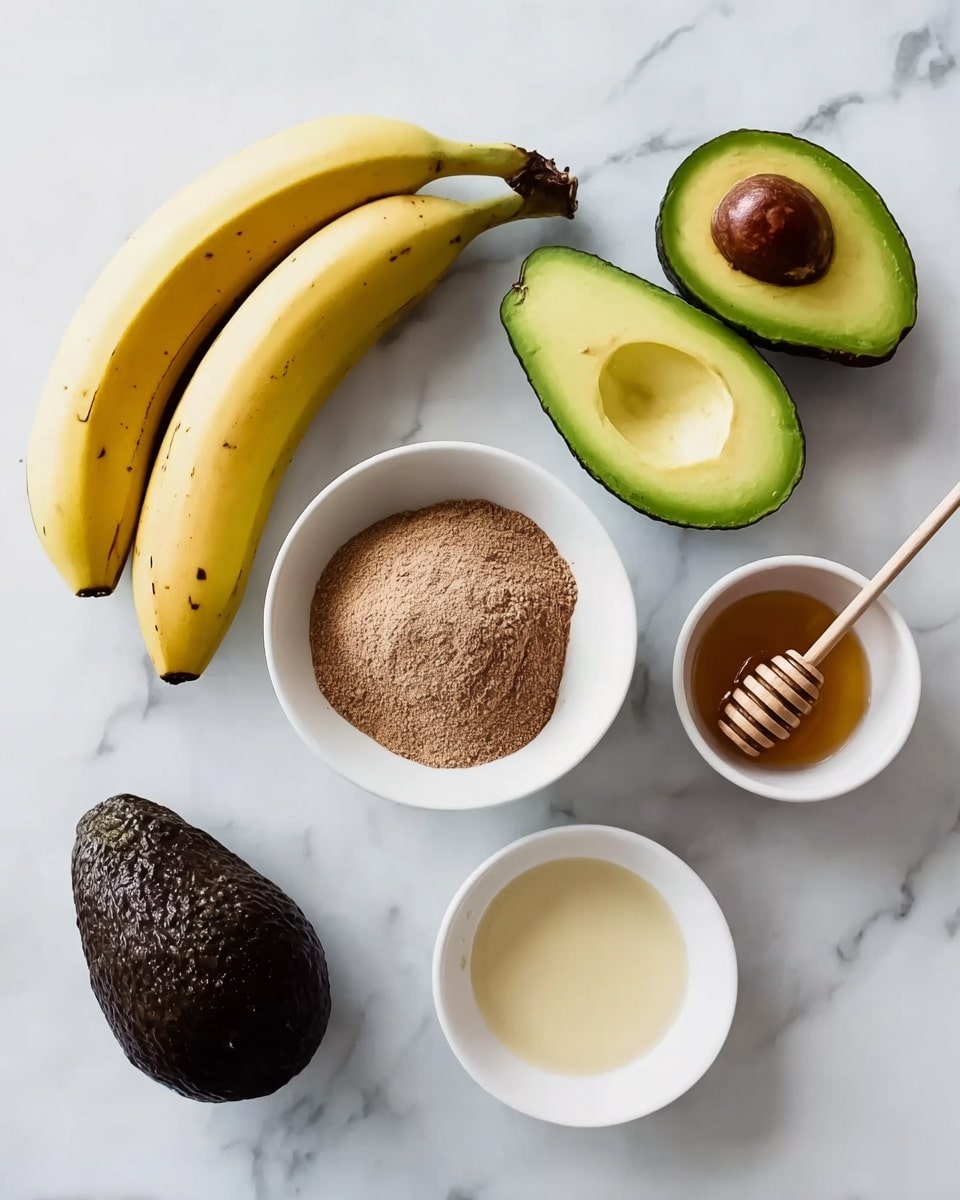 The image shows a white marbled surface holding several food items arranged neatly. On the left, there is a small bunch of yellow bananas with a few dark spots. In the middle, there is a white bowl filled with light brown powder. To the right of the bowl, two avocado halves are shown, one with the large brown seed inside and the other hollow. Below the powder bowl, a whole dark green avocado lies. There are two more small white bowls on the right side: one with a small amount of pale liquid and the other filled with honey, featuring a wooden honey dipper resting inside. photo taken with an iphone --ar 4:5 --v 7