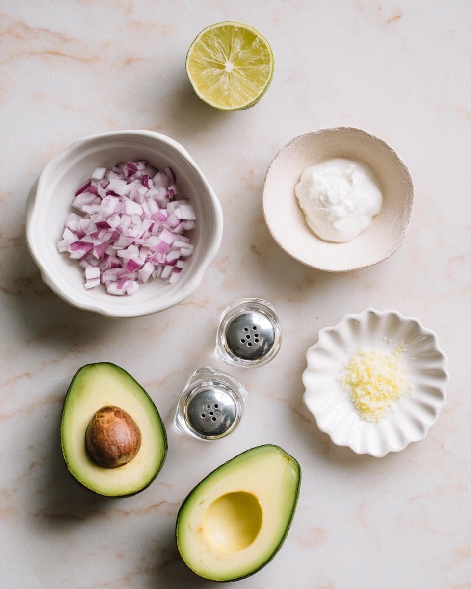 The image shows a white marbled surface with six items arranged on it. At the bottom center, there are two avocado halves, one with a brown pit and the other hollow inside, both showing bright green flesh with darker green skin. Above them, on the left, is a small white bowl filled with finely chopped red onions, showing purple and white colors. To the right of this bowl is a pair of clear glass salt and pepper shakers placed close together. At the top right, there is a small light-colored stone bowl with a creamy white substance inside. At the far right, a small white scalloped dish holds a small amount of yellow, grated or finely chopped ingredient. Near the top left, a half lime slice with a yellow-green color is placed. The photo taken with an iphone --ar 4:5 --v 7