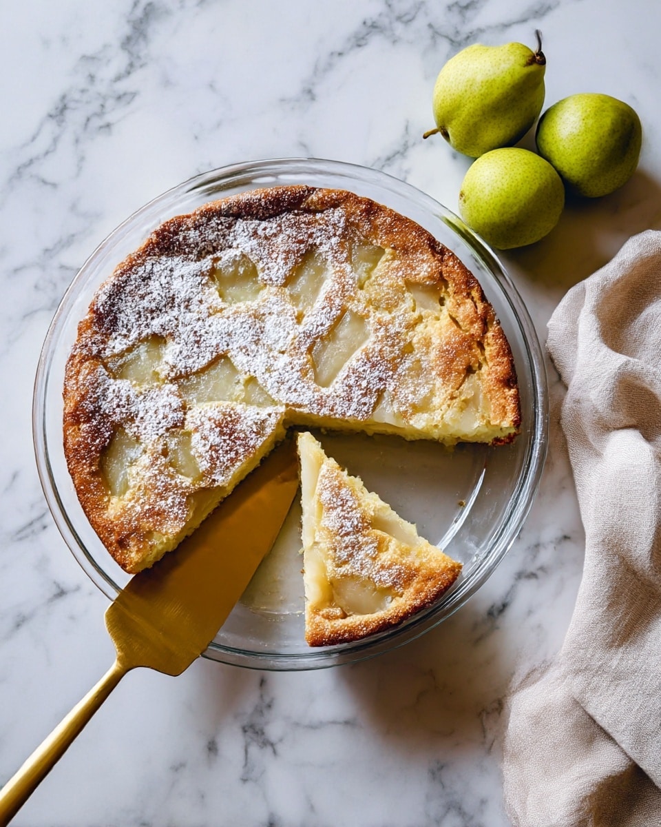 A round pear cake with a golden brown top sprinkled with white powdered sugar sits in a clear glass pie dish on a white marbled surface. The cake shows small pieces of pear embedded in the top layer, with the texture looking soft and slightly spongy. One slice of the cake is lifted slightly on a golden spatula, showing the inside which is light yellow with chunks of pear visible. Nearby, there are three whole green pears and a light beige cloth napkin to the side. Photo taken with an iphone --ar 4:5 --v 7
