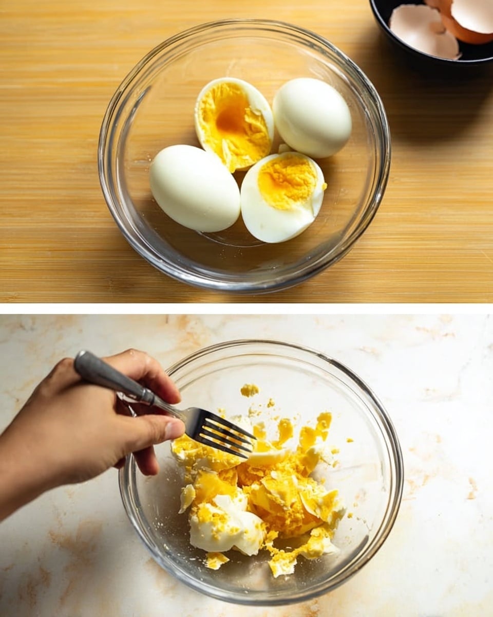 A clear glass bowl sits on a white marbled surface, holding three smooth, white hardboiled eggs in the first image. In the second image, a woman's hand holds a fork inside the same bowl, pressing down on the eggs to break them into small, bright yellow and white pieces, with bits scattered around the bowl’s bottom. In the background, a small black bowl holds some eggshell pieces. photo taken with an iphone --ar 4:5 --v 7
