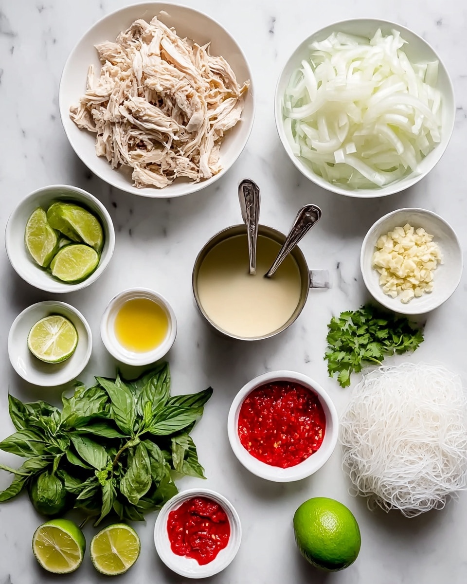 The image shows an overhead view of various ingredients laid out on a white marbled surface. In the top left is a white bowl filled with shredded light brown chicken. Next to it on the right is a white bowl filled with thinly sliced white onions. Below the onions is a stainless steel cup containing a pale, creamy liquid with two spoons inside. Below the chicken is a bunch of fresh green basil leaves. Near the bottom left corner are several lime wedges and half a lime. Next to the limes is a small white bowl with bright red chili paste, followed by a smaller white bowl with a yellow oil and a small amount of minced garlic. To the right is another small white bowl with chopped garlic. A bunch of fresh green cilantro is near the bottom. On the right side, a white bowl holds thin white rice noodles arranged loosely. Near the bottom right is a whole lime. All items are neatly arranged and spaced against the white marble background. Photo taken with an iphone --ar 4:5 --v 7