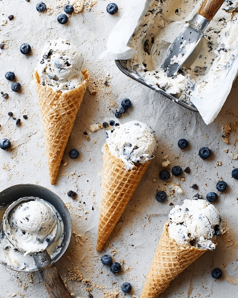 The image shows three waffle cones filled with two scoops each of white ice cream with small dark bits, placed on a rough beige surface scattered with fresh blueberries. One ice cream container lined with white paper is at the top right corner, partially filled with the same ice cream, next to a metal ice cream scoop with ice cream residue. A metal bowl with more ice cream and a wooden spoon rests at the bottom left. The waffle cones are golden brown with a textured grid pattern. The white marbled texture replaces the background. Photo taken with an iphone --ar 4:5 --v 7